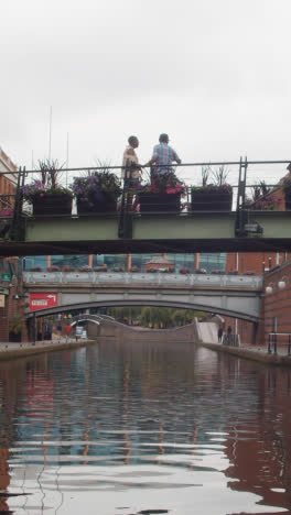 Video-Vertical-De-La-Vista-Desde-El-Barco-Del-Canal-Pasando-Por-Debajo-Del-Puente-En-Brindley-Place-En-Birmingham,-Reino-Unido